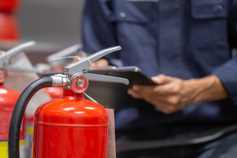 Fire extinguisher standing on table to be inspected by trained technician